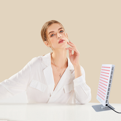 Vrouw zit aan tafel of bureau met tafelmodel voor haar gezicht